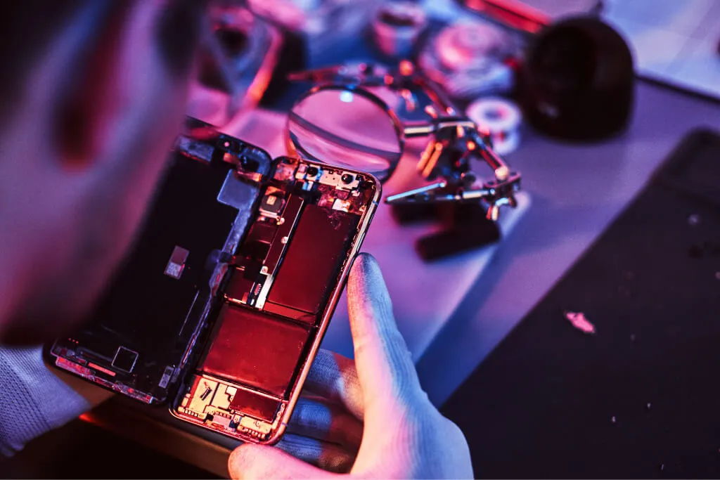 Technician inspecting the internal parts of a device at the INK 4 LESS workbench